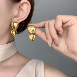 Close-up of double layered heart earrings with high polished gold mirror finish
