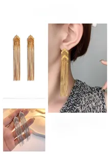 Detail of long 18K gold plated chain tassel earrings with geometric triangle top