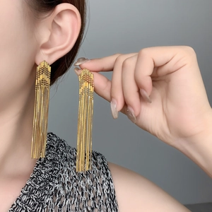 Detail of 18K gold-plated long chain tassel earrings with smooth snake chain texture