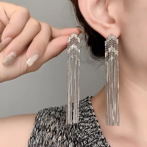 Detail of silver long multi-strand fringe earrings featuring layered geometric tassels