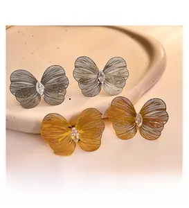 Detailed close-up of hollow butterfly earrings with gold plating and marquise zircon stones