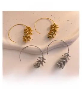 Detailed view of leaf-patterned large hoop earrings in gold and silver plating