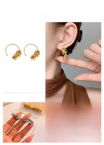 Macro detail of 18K gold plated leaf drop earrings with intricate brushed metal textures