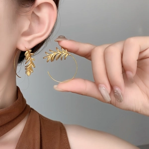 Detailed close-up of 18K gold-plated leaf earrings with intricate vein textures