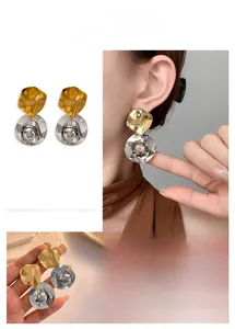 Vue macro de boucles d'oreilles bicolores avec finition plissée or et argent
