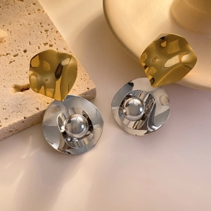 Détail de boucles d'oreilles vagues irrégulières avec finition bicolore or et argent