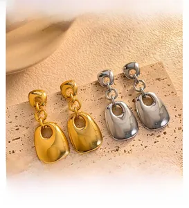 Detailed view of dual-layer geometric 18K gold and silver plated earrings on a stone base