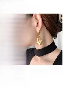 Detail view of gold-plated double-layer geometric square earrings on a model and hand