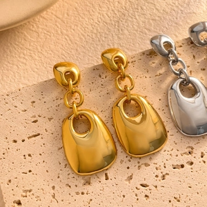 Detail of 18K gold and silver plated geometric double square drop earrings on stone
