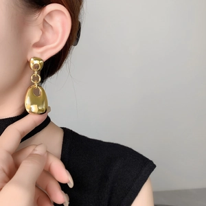 Macro shot of 18K gold plated geometric square drop earrings on model showcasing polished finish