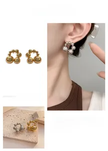 Detailed view of spherical beaded geometric hoop earrings with polished metallic finish