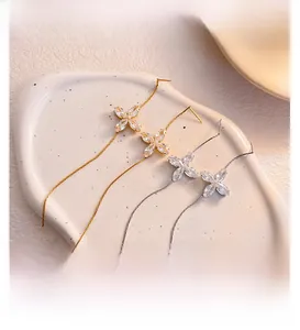 Close-up of four-leaf clover long chain tassel earrings with cubic zirconia stones