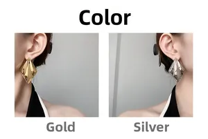 Detail of geometric rhombus earrings in gold and silver finish worn by a model