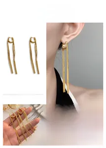 Detailed view of 18K gold plated long chain tassel earrings with U-shaped buckle hooks