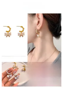 Detailed close-up of bow earrings with blue crystals and textured metal C-hoops