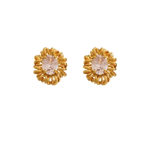 Macro detail of gold flower earrings with oval cubic zirconia in intricate wire design