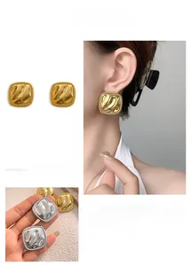 Detail showing irregular wavy texture and polished finish on square geometric stud earrings