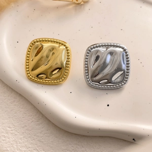 Macro view of square earrings featuring irregular liquid metal texture and milgrain edges