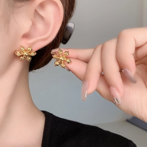 Gros plan de boucles d'oreilles flocon en plaqué or sur un modèle au fini délicat
