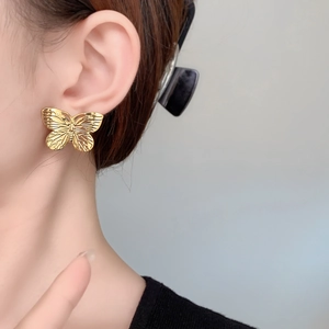 Ohrstecker aus 18 Karat vergoldetem Schmetterling mit Textur an einem Modell