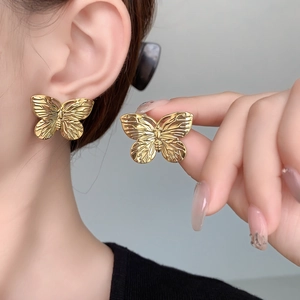 Detailaufnahme der 18K vergoldeten Schmetterlingsstecker mit Vintage-Textur