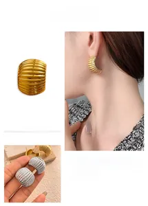 Detailed view of textured metal C-shape earrings in gold and silver finish with ribbed design