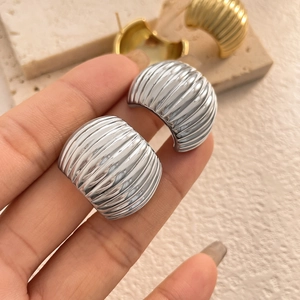 Textured C-shaped hoop earrings with vertical ribbed design in gold and silver finish