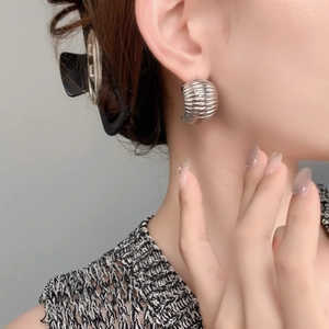 Chic silver croissant C-shaped earrings with textured finish worn by a model