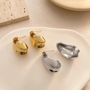 Boucles d'oreilles minimalistes en forme de goutte d'eau dorées et argentées sur plat