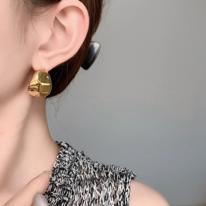 Boucles d'oreilles croissant dorées avec finition miroir polie portées par un mannequin