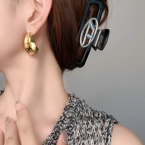 Boucles d'oreilles créoles dorées avec finition miroir large sur un mannequin