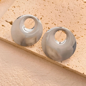 Macro shot of silver circular geometric stud earrings with polished mirror finish details