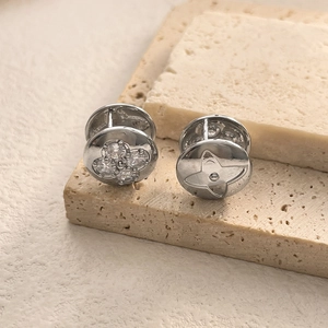 Detailed macro view of silver plated flower earrings with cubic zirconia on a stone base