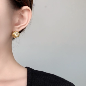 Close-up of gold flower earrings with crystals on female model for elegant style