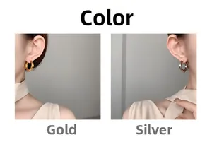 Détail de boucles d'oreilles créoles carrées dorées et argentées portées par un mannequin