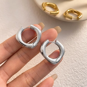 Boucles d'oreilles créoles carrées et ovales minimalistes tenues pour l'échelle