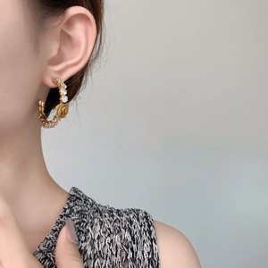 Detailed close-up of large gold-plated hoop earrings with zircon flowers and vintage rose relief