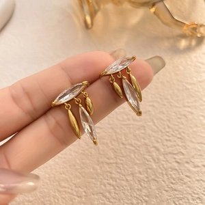 Detailed close-up of gold-plated leaf tassel earrings with marquise-cut zircon stones