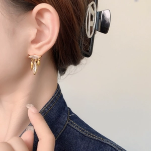Elegant gold leaf tassel earrings with sparkling zircon crystals worn by a model