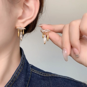 Close-up of elegant leaf tassel gold earrings with marquise and teardrop zircon accents