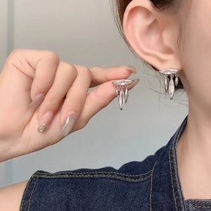 Detailed close-up of leaf tassel earrings with zircon stones and silver finish
