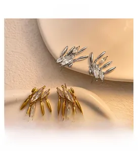Detail of irregular marquise cubic zirconia tassel earrings in gold and silver finish