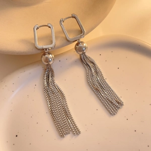 Detail of silver long tassel earrings with square hoop and polished metal bead