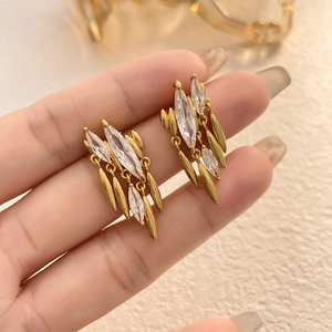 Close-up of golden marquise cubic zirconia tassel earrings on a model's hand