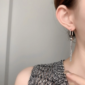Detail of silver long tassel earrings with geometric square hoop and polished metallic bead