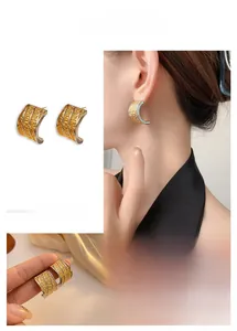 Detail of mixed-color C-shaped earrings with unique volcanic lava hammer texture