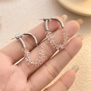 Detail of silver U-shaped hook earrings with delicate light pink crystal bead accents