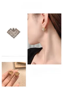 Detail of heart-shaped zircon earrings in gold and silver plating shown on a model