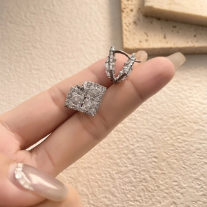 Exquisite square zirconia earrings with 18K gold plating shown in a close-up hand shot