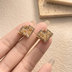 Macro shot of gold heart earring featuring four champagne cubic zirconia stones